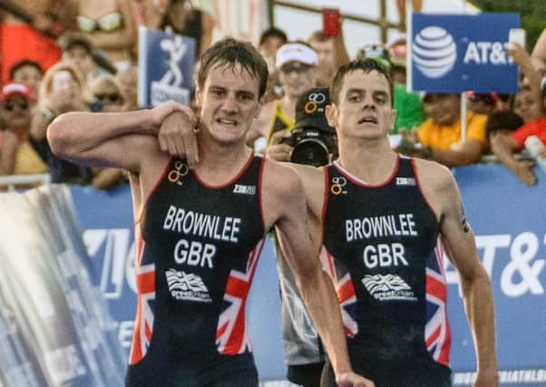Alistair Brownlee (L) helps his brother Jonny before crossing the line. Picture: AFP/Getty
