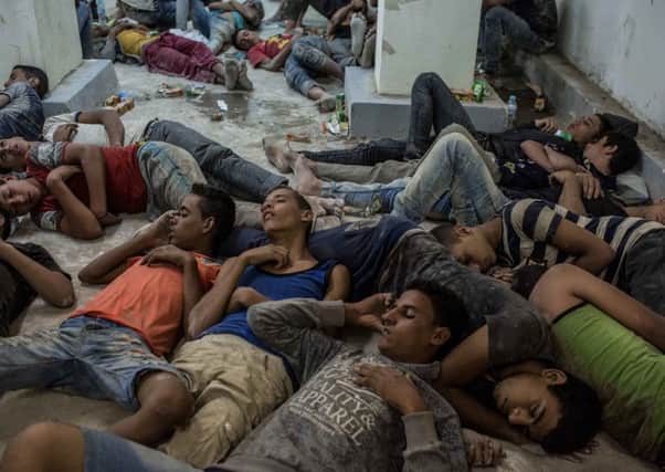 Young Egyptians sleep on the floor of a police station after being detained. They were rescued from the boat that capsized off Alexandria. Picture: AP