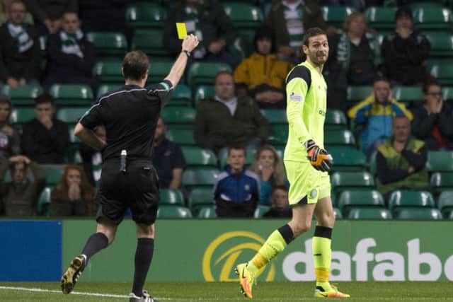 Celtic goalkeeper Craig Gordon is shown the yellow card for a challenge on Alloa's Greig Spence.