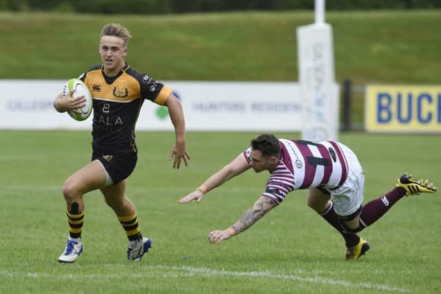 Currie's  Harvey Elms evades the tackle of Watsonians Joe Helps on his way to scoring the first of his two tries. Picture Ian Rutherford