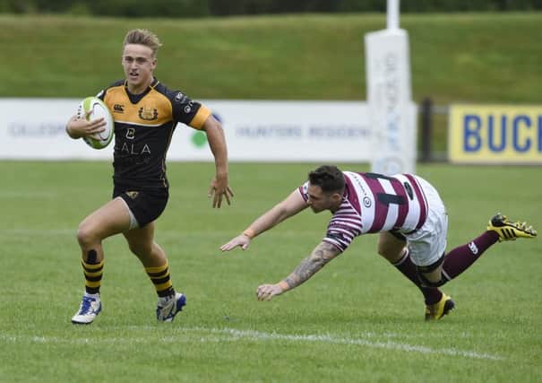 Currie's  Harvey Elms evades the tackle of Watsonians Joe Helps on his way to scoring the first of his two tries. Picture Ian Rutherford