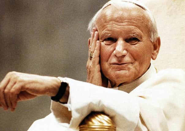 FILE - Pope John Paul II smiles from his papal throne, in this May 16, 1990 file photo, during his weekly general audience, two days prior to his 70th birthday on May 18th. Pope John Paul II died on Saturday, April 2, 2005. (AP Photo/Giulio Broglio)
