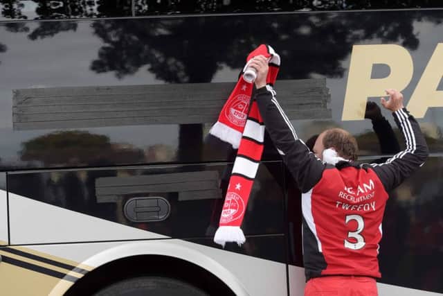 Masking tape covers up the vandalism on the Rangers bus as it arrives at Pittodrie. Picture: SNS
