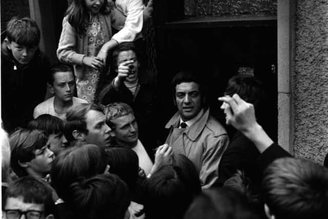 Frankie Vaughan is mobbed by local residents on a visit to Easterhouse in 1968. The singer was fronting a campaign aimed at ending gang violence. Picture: Gordon Rule/TSPL