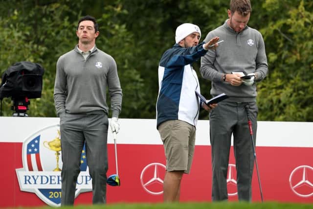 Mark Crane offers Chris Wood some advice during a practice round at Hazeltine today with Rory McIlroy. Picture: Getty Images