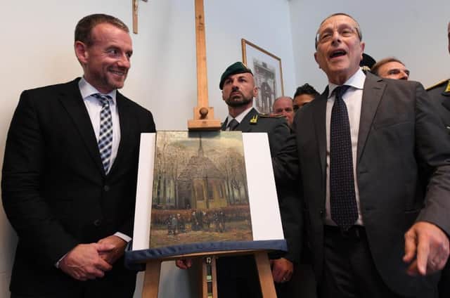 Director of Amsterdam's Van Gogh Museum Axel Ruger, and Naples Prosecutor Giovanni Colangelo, stand next to the painting Congregation Leaving The Reformed Church of Nuenen by Vincent Van Gogh. Picture; AP