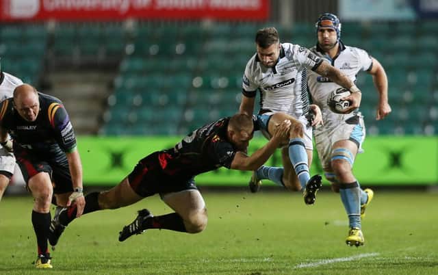 Glasgow winger Rory Hughes tries to skip out of a tackle by Jack Dixon of Newport Gwent Dragons. Picture: Fotosport