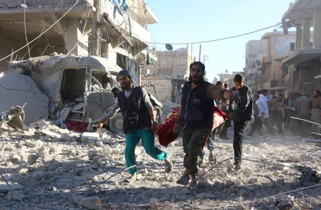Syrian volunteers carry an injured person on a stretcher following Syrian government forces airstrikes on the rebel held neighbourhood of Heluk in Aleppo. Pic: Getty