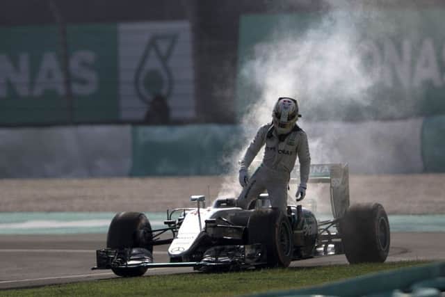 Mercedes driver Lewis Hamilton leaves his car after an engine failure during the Malaysian Grand Prix at the Sepang International Circuit. Picture: AP Photo/Brian Ching