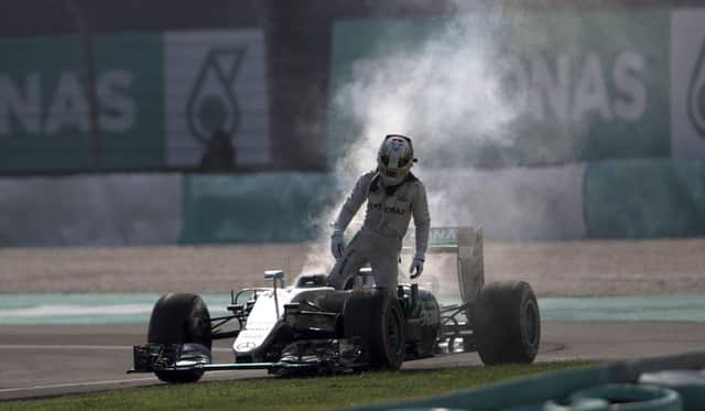 Mercedes driver Lewis Hamilton leaves his car after an engine failure during the Malaysian Grand Prix at the Sepang International Circuit. Picture: AP Photo/Brian Ching