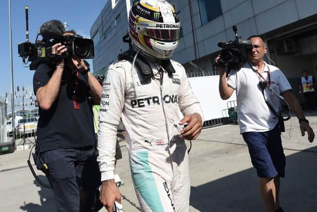 Mercedes AMG Petronas F1 Team's British driver Lewis Hamilton arrives the pit, after his car engine caught fire during the Formula One Malaysian Grand Prix in Sepang on October 2, 2016. / AFP PHOTO / MANAN VATSYAYANAMANAN VATSYAYANA/AFP/Getty Images