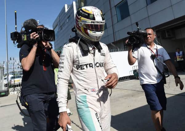 Mercedes AMG Petronas F1 Team's British driver Lewis Hamilton arrives the pit, after his car engine caught fire during the Formula One Malaysian Grand Prix in Sepang on October 2, 2016. / AFP PHOTO / MANAN VATSYAYANAMANAN VATSYAYANA/AFP/Getty Images