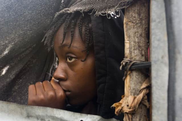 A girl watches as authorities arrive to evacuate people from her house in Tabarre, Haiti, Monday, Oct. 3, 2016. The center of Hurricane Matthew is expected to pass near or over southwestern Haiti on Tuesday, but the area is already experiencing rain from the outer bands of the storm. (AP Photo/Dieu Nalio Chery)