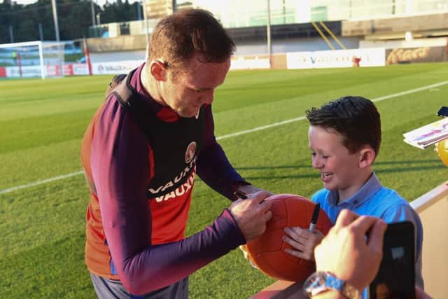 England's striker Wayne Rooney signs autographs for fans after a training session at England's training facility at St George's Park in Burton-upon-Trent, in central England on October 4, 2016, ahead of England's 2018 World Cup qualifying football match against Malta on October 8. / AFP PHOTO / PAUL ELLIS / NOT FOR MARKETING OR ADVERTISING USE / RESTRICTED TO EDITORIAL USEPAUL ELLIS/AFP/Getty Images