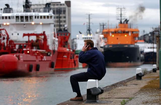 A dock worker takes a break at Aberdeen Harbour in 2012. Picture: Robert Perry/TSPL