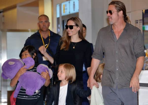 US film stars Brad Pitt (R) and Angelina Jolie (back C), accompanied by their children, arrive at Haneda International Airport in Tokyo on July 28, 2013.  Pitt is now here for the promotion of his latest movie "World War Z".     AFP PHOTO / Yoshikazu TSUNO        (Photo credit should read YOSHIKAZU TSUNO/AFP/Getty Images)