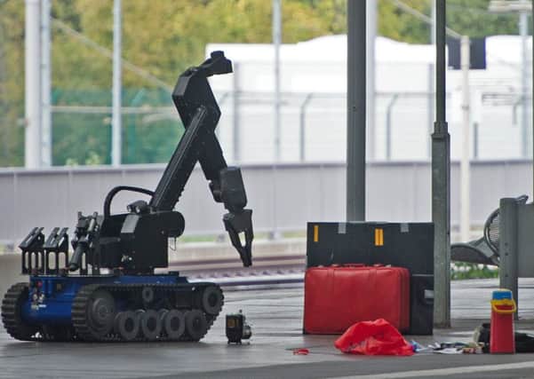 A remotely controlled bomb disposal robot approaches a red suitcase on a platform at the Chemnitz Central Station in eastern Germany. Picture: AP