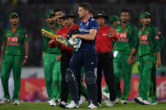 Umpires Aleem Dar and Sharfuddoula usher Jos Buttler away from the Bangladesh fielders after his dismissal. Picture: Gareth Copley/Getty