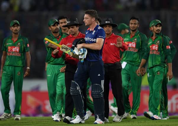 Umpires Aleem Dar and Sharfuddoula usher Jos Buttler away from the Bangladesh fielders after his dismissal. Picture: Gareth Copley/Getty