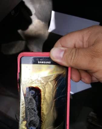 A customer shows his daughters Galaxy Note7 which had melted in her hand. Picture: AP