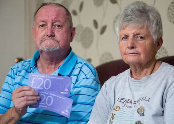 Derek Limbert & Julie Limbert holding the vouchers they were offered as reparation for the holiday from hell. SWNS