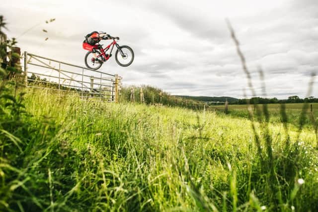 Danny MacAskill performs a bump jump to backwheel over a gate. Picture: Fred Murray/Red Bull