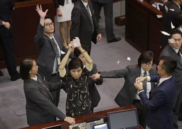 The swearing-in ceremony to kick off Hong Kong's legislative session descenda into farce as pro-democracy lawmakers tear their ballots. Picture Kin Cheung/ PA