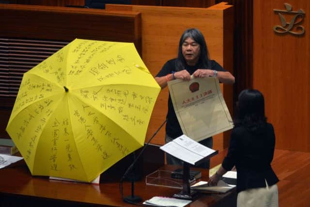 Leung Kwok-hung shouts slogans and rips up the '831 ruling'. Picture: GETTY