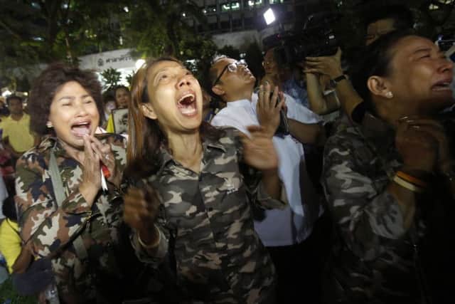 Thai people cry outside Siriraj Hospital where the king is being treated in Bangkok. Picture: AP
