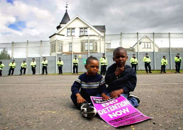 Jay Ilunga (left), aged 2 and his brother Ahmad, 4, sit outside the Dungavel Immigration Removal Centre as part of a protest. Picture: PA