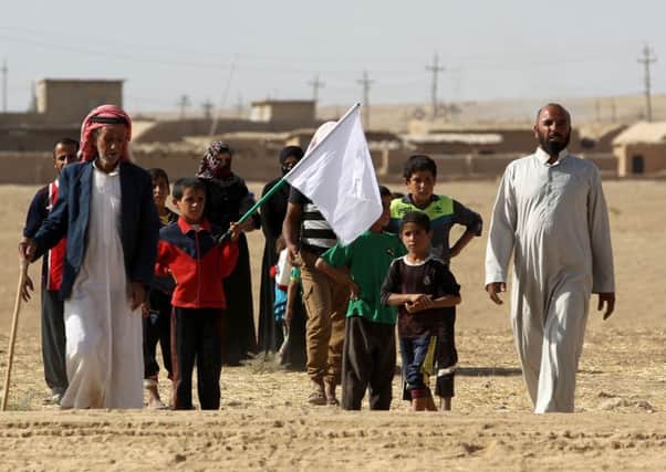 Iraqis from near Mosul carry a white flag as they approach security forces who liberated their village from Islamic State. Picture: AFP/Getty