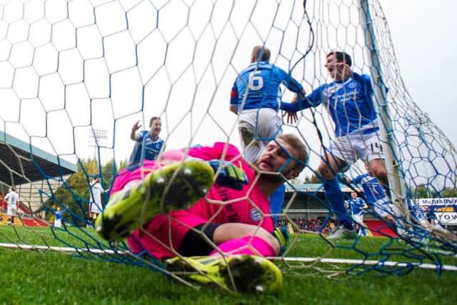 Steven Anderson, centre, jumps for joy after his goal gives St Johnstone the lead and leaves Dundee keeper Scott Bain tied up in his net. Picture: SNS