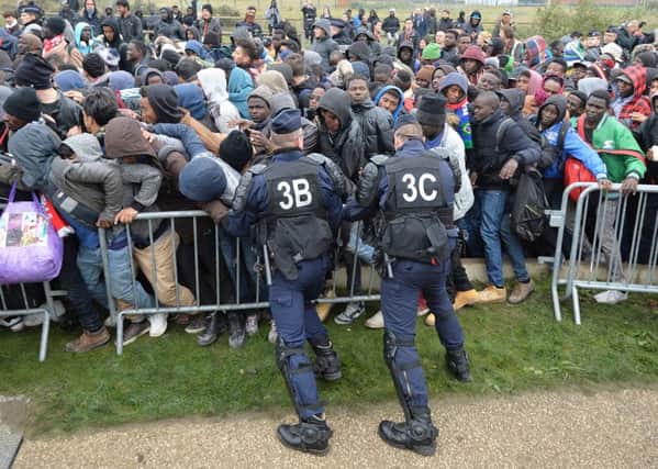 French police officers push back a large crowd of migrants as they line-up at a processing centre in "the jungle" near Calais.
Picture: PA