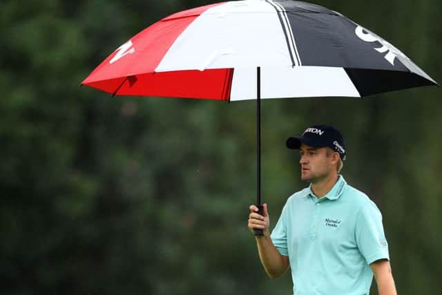 Defending champion Russell Knox shelters under his umbrella during the first round of the WGC-HSBC Champions in Shanghai. Picture: Getty Images