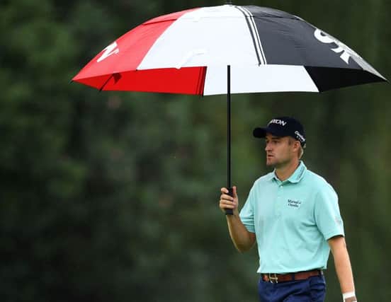 Defending champion Russell Knox shelters under his umbrella during the first round of the WGC-HSBC Champions in Shanghai. Picture: Getty Images