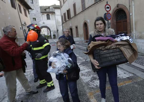 Residents carry some of their belongings in the small town of Visso in central Italy. (AP Photo/Alessandra Tarantino)
