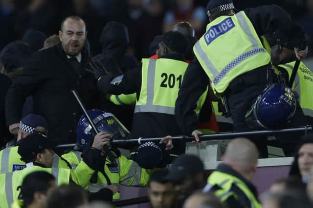 Police move into to separate rival supporters who had clashed with stewards during the EFL Cup match between West Ham United and Chelsea at the London Stadium. Picture: Alastair Grant/AP