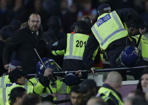 Police move into to separate rival supporters who had clashed with stewards during the EFL Cup match between West Ham United and Chelsea at the London Stadium. Picture: Alastair Grant/AP