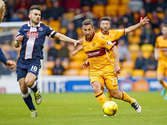 Scott McDonald, right,  passes the ball under pressure from Ross County's Ian McShane. Picture: SNS