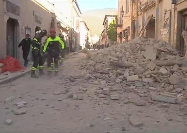 Firefighters clear the road blocked by rubble from a damaged building in Norcia. Picture: AP