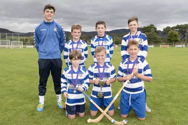 Coach Iain Robinson with his winning Newtonmore team.
Picture: Neil G. Paterson Photography.