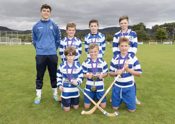 Coach Iain Robinson with his winning Newtonmore team.
 Picture: Neil G. Paterson Photography.