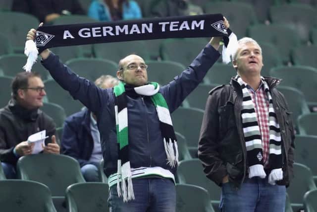 A Borussia Moenchengladbach fan holds a scarf up with ''A German Team'' on prior to kick off. Picture: Getty