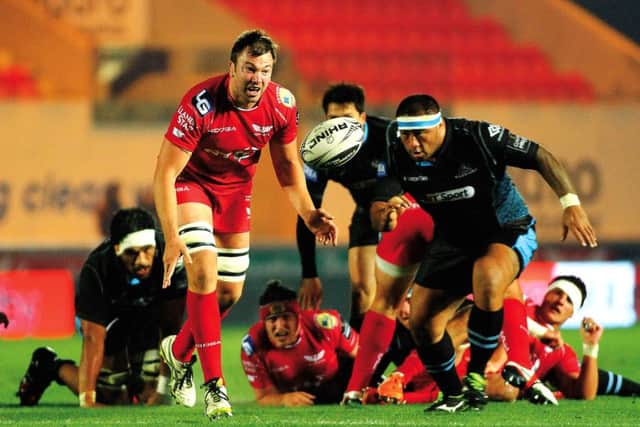 Scarlets David Bulbring get the ball away from a ruck despite the attentions of Sila Puafisi. Picture: David Gibson/Fotosport