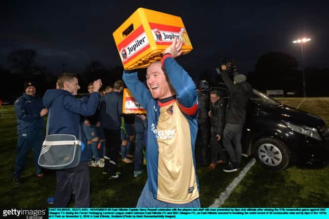 East Kilbride Captain Barry Russell celebrates with beer presented by Ajax club officials. Picture: Getty Images