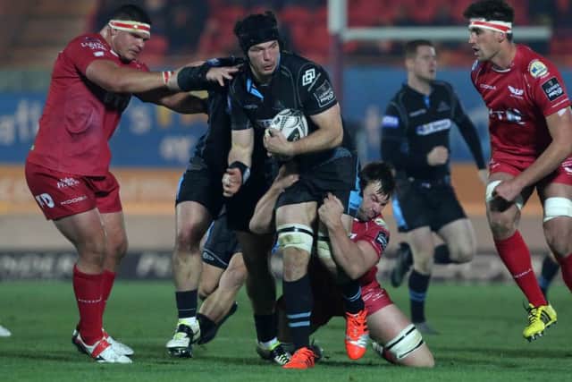 Glasgows Tim Swinson is tackled by Scarlets' David Bulbring and Werner Kruger. Picture: Fotosport.