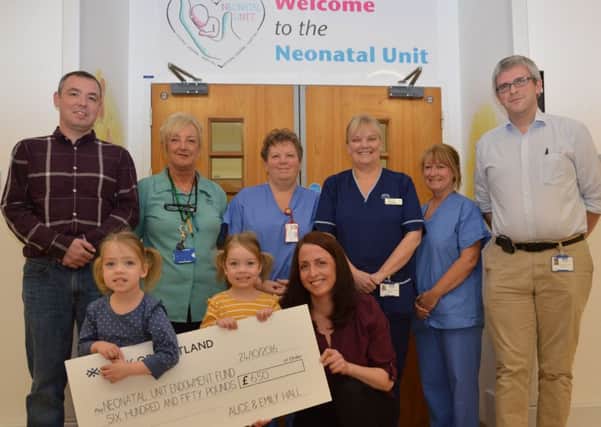 Alice and Emily with mum Margaret (front) and dad Dougie Hall (back left) with staff from the neonatal unit including Dr Duncan Boyd, consultant neonatologist, (back right). Picture: Contributed