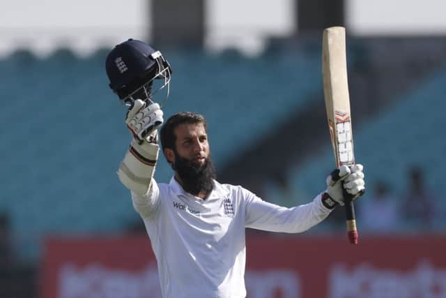 Moeen Ali raises his bat in celebration after completing his century in the first over of the second day in Rajkot. Picture: Rafiq Maqbool/AP