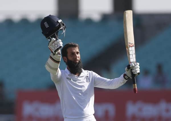 Moeen Ali raises his bat in celebration after completing his century in the first over of the second day in Rajkot. Picture: Rafiq Maqbool/AP