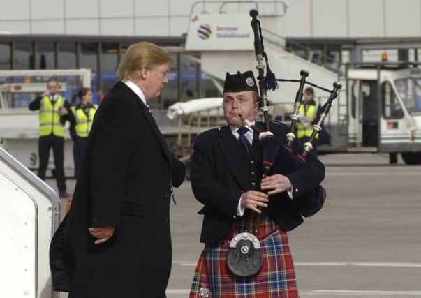 A piper greets Donald Trump on the tarmac on a previous visit to Scotland. Picture: Donald MacLeod